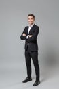 Successful young business man in classic black suit shirt posing isolated on grey wall background studio portrait Royalty Free Stock Photo