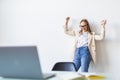 Successful young business woman with arms up at the office Royalty Free Stock Photo