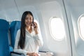 Successful young business woman working speaking on mobile phone while while sitting on aircraft cabinin Royalty Free Stock Photo