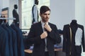 Successful young businessman measures jacket in business mens clothing store. Royalty Free Stock Photo