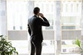Successful young businessman talking on cellphone near windows Royalty Free Stock Photo