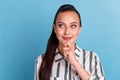 Successful young businesswoman touches chin hand smiling looking isolated on blue background