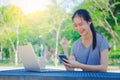 Successful young girl is a university student with cup of coffee and a phone in her hands working on a laptop at the table in the Royalty Free Stock Photo