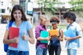 Successful young hispanic female student with group of young adults