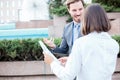 Successful young male and female business people talking in front of an office building, having a meeting and discussing Royalty Free Stock Photo