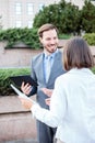 Handsome young male and female business people talking in front of an office building, having a meeting and discussing Royalty Free Stock Photo