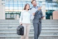 Successful young male and female business partners walking down the stairs in front of an office building Royalty Free Stock Photo