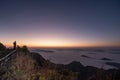 Successful young man backpacker on top of a mountain.Hiker standing on mountain peak waiting for sunrise Royalty Free Stock Photo