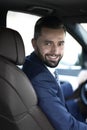 Handsome young man sitting in the front seat of a car looking at the camera Royalty Free Stock Photo