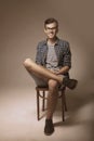 Successful young man sitting on vintage chair with his crossed l Royalty Free Stock Photo