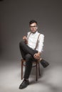 Successful young man sitting on vintage chair with his crossed l Royalty Free Stock Photo