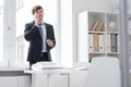 Successful Young Man Speaking by Phone in Office Royalty Free Stock Photo