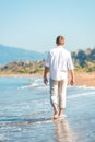 Successful young man walking along a beach Royalty Free Stock Photo