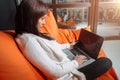 Successful young woman sitting on sofa in office, working on her laptop. Royalty Free Stock Photo