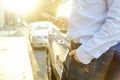 Successfull happy young man and his car in soft sunset light on urbanistic background. Busines man with vehicle on roadside. Royalty Free Stock Photo