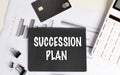 Succession plan text on black paper with charts, calculator and office accessories Royalty Free Stock Photo
