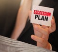 Succession Plan words on a card in hand of businessman. Business profit and success concept Royalty Free Stock Photo