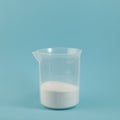 Succinic acid powder in measuring plastic cup Royalty Free Stock Photo