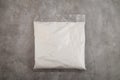 Succinic acid powder in plastic bag on grey background. Butanedioic acid or spirit of amber. White powder,