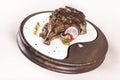 Succulent grilled large t-bone steak garnished with herbs, radish and salt, on a white plate, brown background Royalty Free Stock Photo