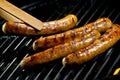 Succulent juicy sausages grilling on a BBQ Royalty Free Stock Photo