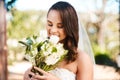 Such a beautiful scent. a beautiful young bride smiling while holding a bouquet of flowers on her wedding day. Royalty Free Stock Photo