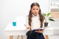 Such difficult topic. Studying difficulties. Girl read book while stand table white interior. Schoolgirl studying Royalty Free Stock Photo