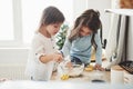 Such are focused on work. Preschool friends learning how to cook with flour in the white kitchen