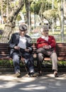 Elderly Bolivian couple seat on a bench in the main square of Sucre, Bolivia