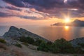 Sudak, Crimea - a view from Cape Meganom. Sunset sky with beautiful clouds. The Black Sea and the ridge of the Crimean mountains. Royalty Free Stock Photo