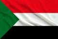 Sudan flag on gentle silk with folds in the wind