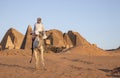 Sudanese man with his camel in a desert near Meroe Pyramids