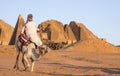 Sudanese man with his camel in a desert near Meroe Pyramids