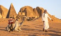 Sudanese man with his camel in a desert near Meroe Pyramids