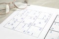 Sudoku and eyeglasses on table, closeup view Royalty Free Stock Photo