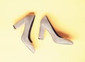 Suede footwear concept. Pair of fashionable high heeled shoes. Shoes made out of grey suede on yellow background Royalty Free Stock Photo