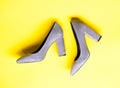 Suede footwear concept. Pair of fashionable high heeled shoes. Shoes made out of grey suede on yellow background Royalty Free Stock Photo