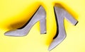 Suede footwear concept. Shoes made out of grey suede on yellow background. Footwear for women with thick high heels, top Royalty Free Stock Photo