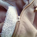 Suede outerwear. Overhead loops for buttons. Open zipper. Beige faux suede with sheepskin on the fold of a demi-season