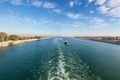 Suez Canal in Egypt. Tugboat accompanies the ships. Royalty Free Stock Photo