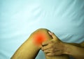 Suffering from joint pain with red spot. Hands on leg as hurt from Arthritis. Osteoarthritis knee disease concept Royalty Free Stock Photo