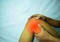 Suffering from joint pain with red spot. Hands on leg as hurt from Arthritis. Osteoarthritis knee disease concept Royalty Free Stock Photo