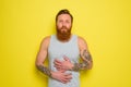 Suffering man with beard and tattoos has stomach ache Royalty Free Stock Photo