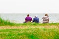 Back view of a family sitting on Minsmere beach in the UK