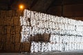 Sugar bags stack in pile inside warehouse for export.