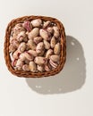 Sugar Bean legume. Wicker basket with grains. Top view, hard light. Royalty Free Stock Photo