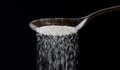 Close up of spoon pouring granulated refine white sugar