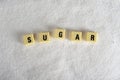 Sugar block letters in crossword over sugar pile isolated on grainy white sugar texture in sweet food abuse