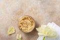 Sugar body scrub in glass jar on stone table. Homemade cosmetic for spa