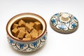 sugar bowl with brown sugar cubes stands on a white background